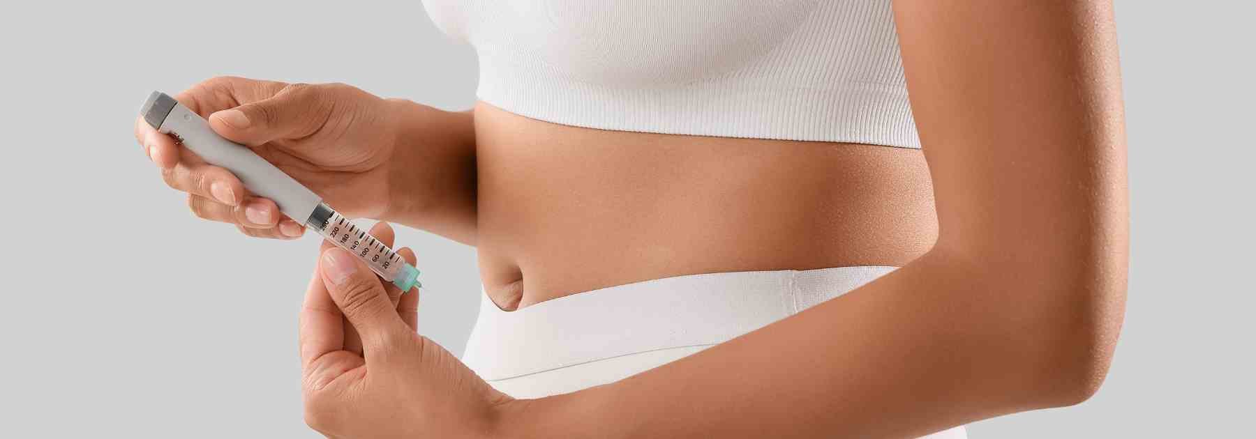 Woman in white gym gear using weight loss pen