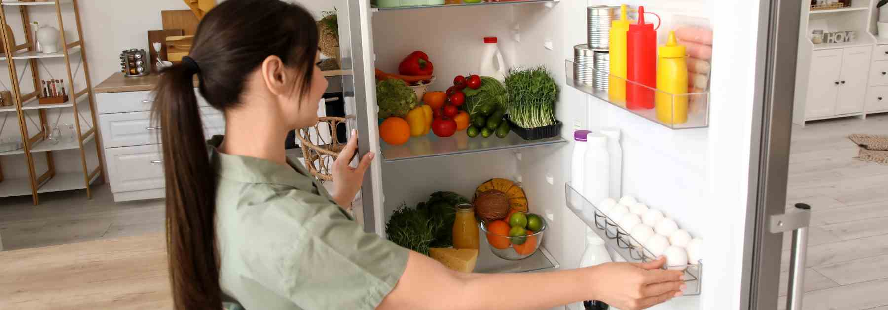Woman looking for healthy food in the fridge