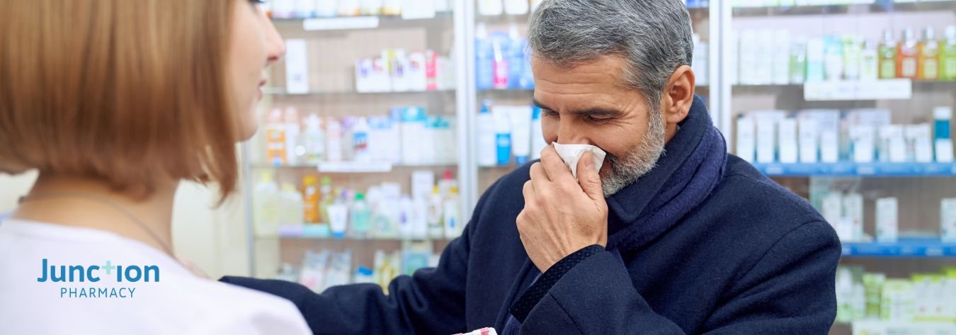 Man blowing his nose in a pharmacy